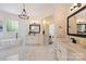 Bright bathroom featuring a soaking tub, marble floors, and double sink vanity at 133 Crooked Branch Way, Troutman, NC 28166