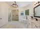 Bright bathroom with soaking tub, glass shower, double vanity, and marble tile at 133 Crooked Branch Way, Troutman, NC 28166