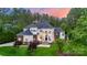 Majestic home boasts a grand entrance with stone accents, lush landscaping, and a well-manicured lawn at 133 Crooked Branch Way, Troutman, NC 28166
