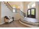 Welcoming foyer with a grand staircase, hardwood floors, and a charming sitting area, creating a warm ambiance at 133 Crooked Branch Way, Troutman, NC 28166
