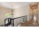 Upstairs hallway featuring wood floors and an ornate chandelier at 133 Crooked Branch Way, Troutman, NC 28166