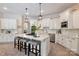 Elegant kitchen with white cabinetry, granite countertops, stainless steel appliances, and a center island with bar seating at 133 Crooked Branch Way, Troutman, NC 28166