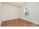 Bedroom with a single window that brings in natural light and beautiful dark wood floors at 13514 Tartarian Ct, Charlotte, NC 28215