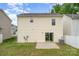 Back exterior of a yellow vinyl-sided home with a small patio and fenced-in yard at 13514 Tartarian Ct, Charlotte, NC 28215