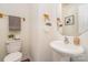 Fresh half bathroom with pedestal sink, wooden accents, and clean design at 13514 Tartarian Ct, Charlotte, NC 28215