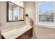 Bathroom featuring a dark wood vanity, stone countertop, and framed mirror at 140 Parkview St, Davidson, NC 28036