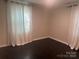 Bedroom with dark floors, neutral walls and light curtains at 1401 Anderson St, Charlotte, NC 28205