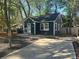 Cozy single-story home with dark siding, a paved driveway, and mature trees in the yard at 1401 Anderson St, Charlotte, NC 28205