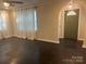Bright living room with dark floors, white curtains and an open doorway at 1401 Anderson St, Charlotte, NC 28205