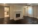 Comfortable living room with decorative fireplace, dark floors and view to kitchen at 1401 Anderson St, Charlotte, NC 28205