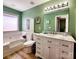 Bathroom featuring a soaking tub, white vanity with marble top, and decorative elements at 14522 Waterside Dr, Charlotte, NC 28278