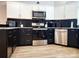 Modern kitchen featuring stainless steel appliances and contrasting black and white cabinetry at 14522 Waterside Dr, Charlotte, NC 28278