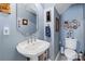 Stylish powder room with a pedestal sink, a decorative mirror, and blue walls at 1511 Elkhart Cir, Gaston, NC 28054
