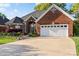 Charming brick home with an attached two-car garage, mature trees, and a well-maintained front lawn at 1511 Elkhart Cir, Gaston, NC 28054
