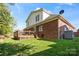 Back exterior of home with a deck, brick facade, lush lawn, and mature trees at 1511 Elkhart Cir, Gaston, NC 28054