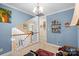 Bright hallway with white railings, a red patterned rug, and decorative artwork at 1511 Elkhart Cir, Gaston, NC 28054