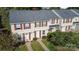 Aerial view of townhouse exteriors featuring brown shutters and light-colored siding, with a lake in the background at 158 Water Oak Dr, Pineville, NC 28134