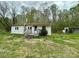 Quaint one-story home with a small porch and mature trees, set against a cloudy sky at 181 Canipe Rd, Dallas, NC 28034