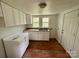 A kitchen with white cabinets, a double sink, and wood-look flooring at 181 Canipe Rd, Dallas, NC 28034