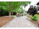 Backyard with a stone fire pit, wooden benches, a storage shed, and manicured garden at 1811 Robbins Meadows Dr, Waxhaw, NC 28173