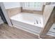 Bathroom featuring a white tub with tiled walls and a window for natural light at 1811 Robbins Meadows Dr, Waxhaw, NC 28173