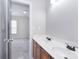 Bathroom featuring double sinks and wooden cabinets with a view into another room at 1811 Robbins Meadows Dr, Waxhaw, NC 28173