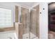 Bathroom featuring a shower with glass door, tiled walls, and a window at 1811 Robbins Meadows Dr, Waxhaw, NC 28173