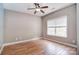 Serene bedroom featuring wood floors, a ceiling fan, and a large window for natural light at 1811 Robbins Meadows Dr, Waxhaw, NC 28173