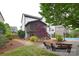 Exterior view of home with screened porch, manicured lawn, and a brick fire pit area at 1811 Robbins Meadows Dr, Waxhaw, NC 28173