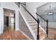 Staircase with decorative accent wall, hardwood floors, and black and white railing providing an eye-catching foyer design at 1811 Robbins Meadows Dr, Waxhaw, NC 28173