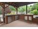 The outdoor kitchen with stainless steel refrigerator, grill, and wood cabinets at 1811 Robbins Meadows Dr, Waxhaw, NC 28173