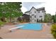 In-ground pool in a backyard with a covered porch and a diving board at 1811 Robbins Meadows Dr, Waxhaw, NC 28173