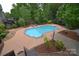 Aerial view of a pristine backyard swimming pool with surrounding patio and lush landscaping at 1811 Robbins Meadows Dr, Waxhaw, NC 28173