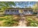 Charming single-story home with a gray brick exterior, black shutters, and a bright yellow front door at 1860 Rosemont St, Salisbury, NC 28144