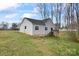 Back exterior view of home with gray siding, deck, and spacious yard with a wooded area at 1870 Beth Haven Church Rd, Denver, NC 28037