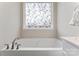 Bathroom featuring a bathtub with decorative window and chrome faucet at 1870 Beth Haven Church Rd, Denver, NC 28037