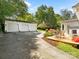 Large driveway leads to a detached garage; the backyard includes a lovely deck, landscaping, and charming seating at 1927 S Wendover Rd, Charlotte, NC 28211