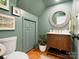 Charming powder room with olive green walls, unique mirror, and elegant fixtures at 1927 S Wendover Rd, Charlotte, NC 28211