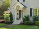 An inviting entrance with a covered porch, stylish door and manicured landscaping at 1927 S Wendover Rd, Charlotte, NC 28211
