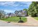 Inviting home with a lush green lawn, complemented by mature trees and a long driveway leading to the garages at 1930 Southridge Dr, Belmont, NC 28012