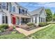Beautiful home featuring a red front door, meticulously landscaped flowerbeds, and a welcoming covered front porch at 1930 Southridge Dr, Belmont, NC 28012