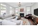 Bright living room featuring a fireplace, plush sofa, and large windows for natural light at 1930 Southridge Dr, Belmont, NC 28012