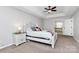 Bright main bedroom featuring a tray ceiling, carpet flooring, and access to the main bathroom at 1930 Southridge Dr, Belmont, NC 28012