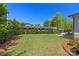 Spacious backyard featuring lush greenery, mature trees, manicured landscaping, and an outdoor patio at 1976 Ferncliff Rd, Charlotte, NC 28211