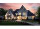 Stunning white brick home with manicured lawn, welcoming entrance, and a lovely dusk sky at 1976 Ferncliff Rd, Charlotte, NC 28211