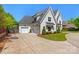 Stunning two-story white brick home with a three-car garage and a well-manicured lawn at 1976 Ferncliff Rd, Charlotte, NC 28211
