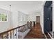 Bright hallway features hardwood floors, white paneled walls, iron railing, and elegant light fixtures at 1976 Ferncliff Rd, Charlotte, NC 28211