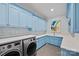 Well-organized laundry room with blue cabinets, countertops, and modern washer/dryer at 1976 Ferncliff Rd, Charlotte, NC 28211