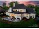Aerial view of backyard with white brick home, stone patio with seating, and lush lawn at 1976 Ferncliff Rd, Charlotte, NC 28211