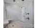Walk-in shower with marble walls, hexagon tile flooring, and built-in bench at 1976 Ferncliff Rd, Charlotte, NC 28211